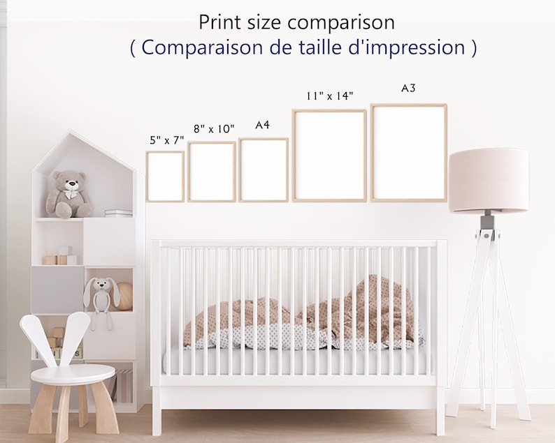 May include: A white crib with a brown and white patterned blanket. The crib is in a nursery with a white bookshelf, a white bunny chair, and a lamp with a pink shade. The wall has a print size comparison chart with different sizes of prints in inches and centimeters.