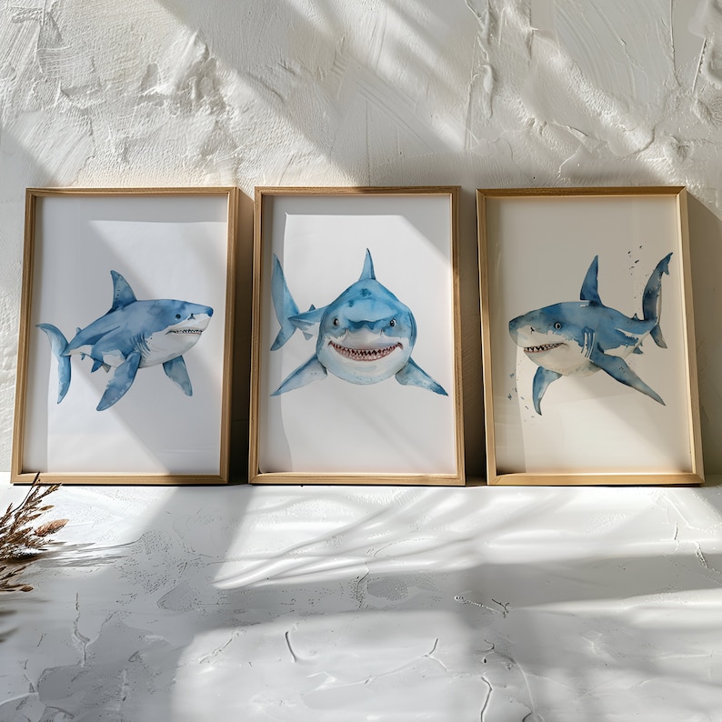 May include: Three framed watercolor paintings of blue and white sharks. Each painting features a different shark pose, with one shark looking directly at the viewer.