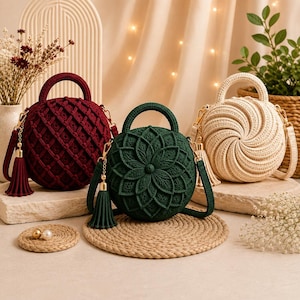 May include: Three round, crocheted handbags in burgundy, dark green, and cream. The burgundy bag features a grid pattern, the green bag has a floral petal design, and the cream bag has a spiral pattern. Each bag includes a handle and a tassel.