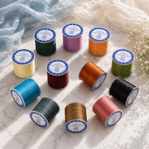May include: Twelve spools of Zeyen's Leather Craft waxed thread in various colors including dark green, purple, orange, yellow, maroon, brown, blue, black, olive green, and pink. Each spool features a white label with blue text and a crown icon.