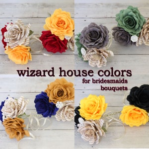 Puede incluir: Colores de las casas de los magos para los ramos de las damas de honor. Los ramos est&aacute;n hechos de flores de papel en amarillo, rojo, azul, verde, negro y gris. Los ramos est&aacute;n dispuestos en una fila sobre una superficie de madera.