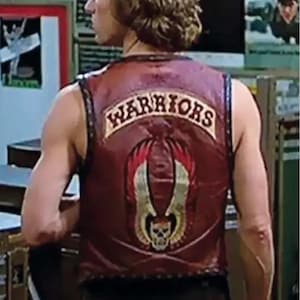 May include: A maroon leather waistcoat featuring a black collar and trim. The back displays the text WARRIORS in a curved arch above a graphic of a skull with large, stylized wings in shades of gold, red, and black, all centred on the back panel.