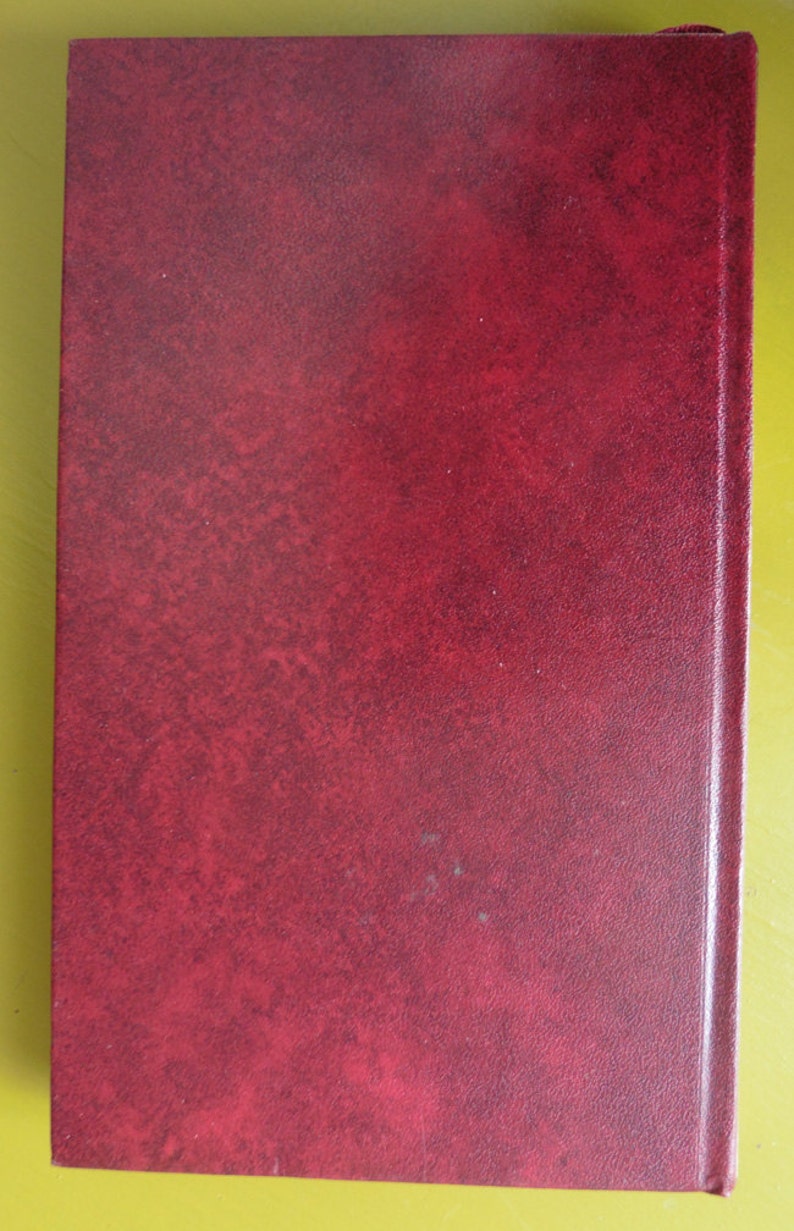 K&ouml;nnte beinhalten: Ein tief rotes, ledergebundenes Buch mit einem strukturierten Einband.