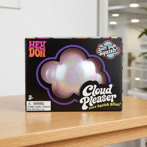May include: A black rectangular toy box featuring the text HEY DON and Cloud Pleaser pure Squish Bliss. The box has a cloud-shaped cutout revealing an iridescent, pearlescent, light-reflecting squishy toy inside. Includes a 3+ age rating label.