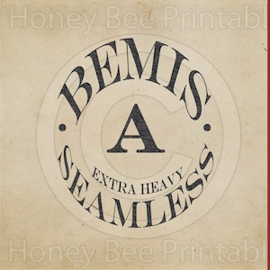 Puede incluir: Un logotipo de estilo vintage con el texto "Bemis" y "Seamless" en un círculo alrededor de la letra "A". El texto "Extra Heavy" está escrito debajo de la letra "A".