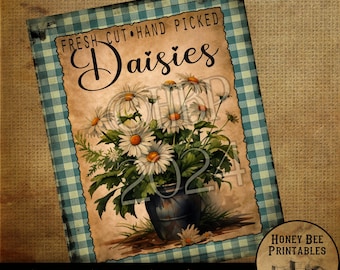 May include: Printable sign with a blue and white gingham border. The sign features a vintage illustration of a bouquet of white daisies in a blue vase. The text on the sign reads "FRESH CUT HAND PICKED Daisies".