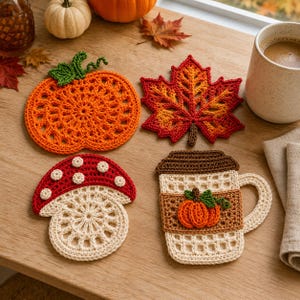 Puede incluir: Cuatro posavasos de ganchillo con motivos otoñales: una calabaza naranja con tallo verde, una hoja de arce roja y naranja, una seta roja y blanca, y una taza de café beige con tapa marrón y una pequeña aplicación de calabaza naranja.