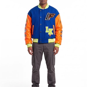 May include: A blue varsity jacket with orange sleeves, featuring the letters LF and LX in neon yellow and black, a snap-button front, and striped ribbed cuffs. The jacket is paired with dark gray cargo pants and gray athletic sneakers.