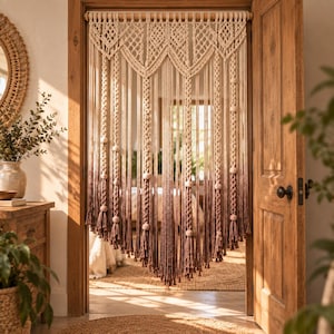 May include: A macrame door curtain featuring an intricate knotted pattern at the top, transitioning from a cream color into a deep brown ombre gradient at the bottom, accented with wooden beads and finished with long, dangling fringe tassels.