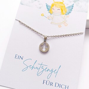 May include: A silver necklace with a pendant featuring a cutout angel design. The necklace is displayed on a white card with a watercolor illustration of an angel and the text "EIN Schutzengel F&Uuml;R DICH".