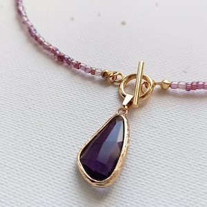 Halskette aus Glasperlen lila violett mit Glasanhänger facettiert