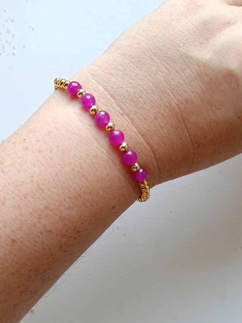 May include: A pink and gold beaded bracelet with a stretchy band.