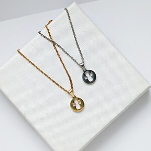 May include: Two silver necklaces with angel pendants. One necklace has a gold pendant and the other has a silver pendant.