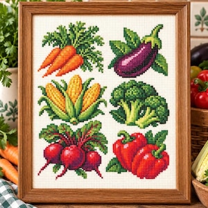 May include: A framed cross-stitch embroidery featuring six colorful vegetables on a white fabric background. The design displays orange carrots, a purple eggplant, yellow corn, green broccoli, red beets, and red bell peppers in a grid.