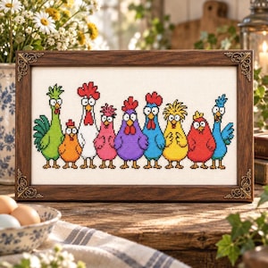May include: A rectangular cross-stitch artwork in a dark brown wooden frame with ornate corner details. The embroidery features a horizontal row of nine colourful, cartoon-style chickens in green, orange, white, pink, purple, blue, yellow, red, and teal.