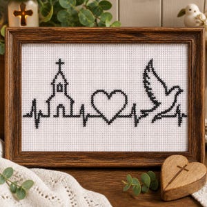 May include: A framed cross-stitch embroidery on white Aida cloth featuring a black thread design of a heartbeat line. The pattern includes a church silhouette, a heart shape, and a flying dove integrated into the continuous pulse line.