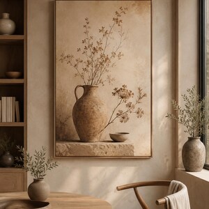 May include: A framed wall art print featuring a textured beige and brown still life composition. The image displays a large, rustic clay jug and a small bowl resting on a stone ledge, accompanied by delicate, dried botanical branches.