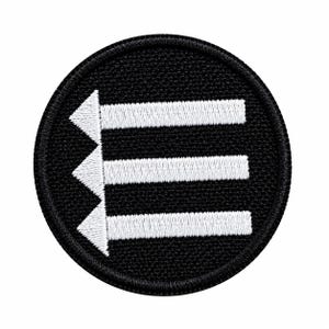 May include: A circular embroidered patch featuring a black background with a white stitched design. The design consists of three horizontal white bars extending from three white triangular arrowheads pointing to the left, forming an E shape.
