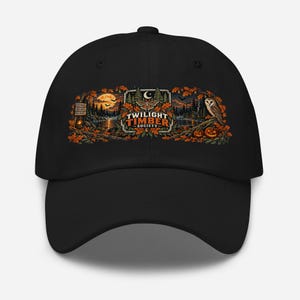 May include: A black baseball cap featuring a detailed graphic print of a forest scene at night with a full moon, an owl, pumpkins, and a moth. The text "TWILIGHT TIMBER SOCIETY" is centered in the design, surrounded by autumn leaves and trees.