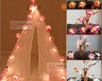 May include: String lights with pink flower shaped bulbs wrapped around a white teepee tent. The lights are also shown wrapped around branches with pink, purple, and blue flower shaped bulbs. The text "MARWIN CRAFT" is visible on the image.
