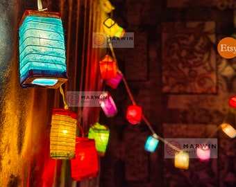 May include: A string of colorful paper lanterns with lights inside, hanging from a ceiling. The lanterns are in various shades of red, orange, yellow, green, blue, and purple. The text "Marwin Craft" and "Etsy" are visible in the image.