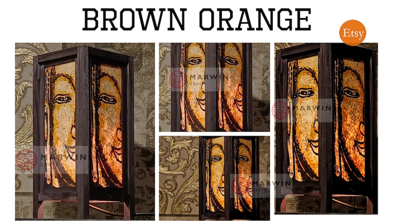 May include: A brown wooden lamp with a glass panel featuring a stylized orange and yellow face. The lamp has a square base and a rectangular shade. The lamp is lit and the face is illuminated. The lamp is labeled "Marwin" on the side.