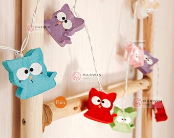 May include: A string of lights with colorful cat-shaped light covers. The lights are strung on a wooden ladder. The cat shapes are blue, purple, pink, red, and green.