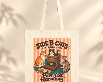 May include: A cream-coloured canvas tote bag featuring a graphic of three cats around a record player. The text reads SIDE B CATS LISTENING CLUB and Purr-fect Harmony. The design includes a striped background and a wooden crate.