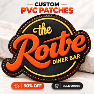 Könnte beinhalten: Ein individueller PVC-Aufnäher mit schwarzer, kreisförmiger Basis, einem erhabenen orangefarbenen Schriftzug the Route und darunter gelbem Text DINER BAR. Der Aufnäher hat einen dicken schwarzen Rand mit orangefarbenen Nahtdetails.