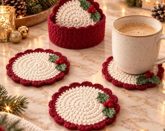 May include: A set of round, crocheted coasters featuring a cream-coloured centre, a deep red scalloped border, and a small green holly leaf and red berry appliqué. The set includes a matching circular holder for storing the coasters.