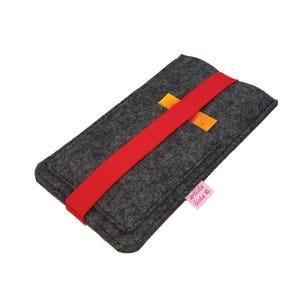 May include: A grey felt sleeve with a red elastic band closure. The sleeve has two small orange pockets and a pink label with the text "artista lista".