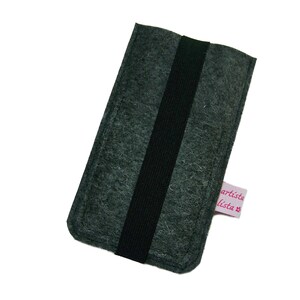 May include: A gray felt phone case with a black elastic band and a pink label that says "artista lista"