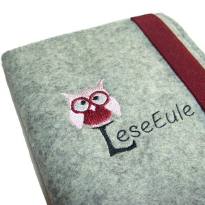 Könnte beinhalten: Grauer Filzbuchumschlag mit einer gestickten rosa und roten Eule und dem Text "Leseeule".