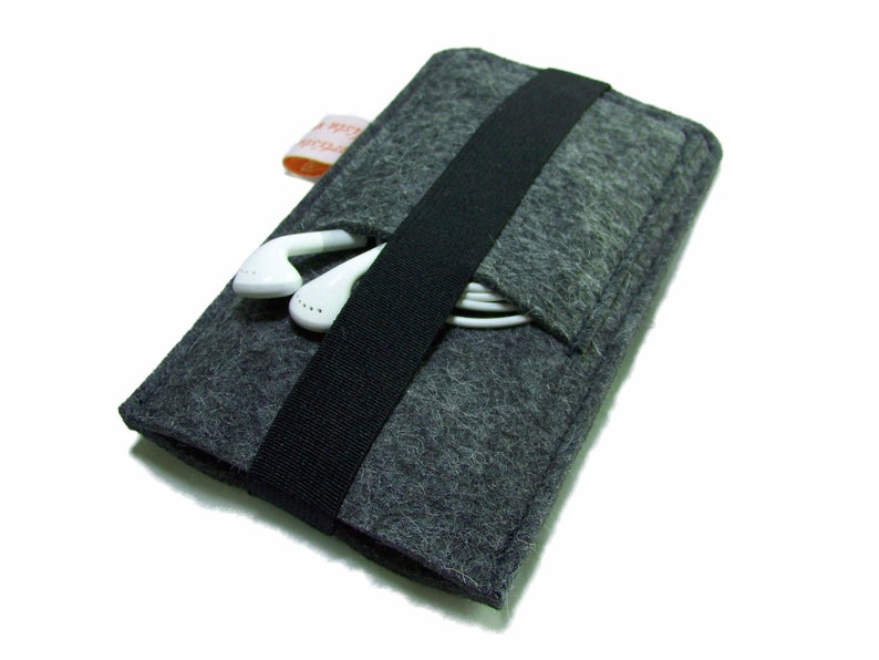 May include: A gray felt phone case with a black elastic band and a pocket for headphones. The case is designed to hold a smartphone and headphones.