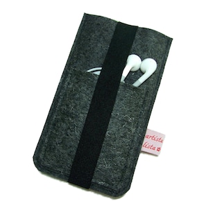 May include: A gray felt phone case with a black elastic band and a small pink label that says "artista lista" in red lettering.