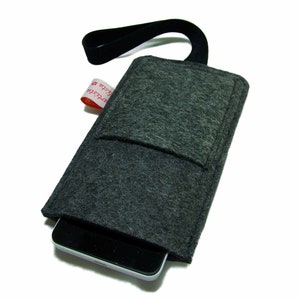 May include: A gray felt phone case with a black strap and a small pocket on the front. The case has a red label with the text "#C-Store" on it.