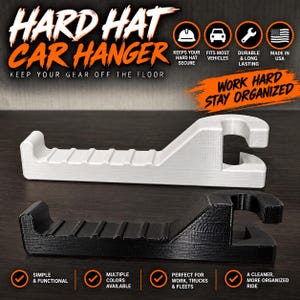 May include: Two hard hat car hangers, one white and one black, featuring a horizontal grooved arm and a circular mounting hook. The text reads HARD HAT CAR HANGER, KEEP YOUR GEAR OFF THE FLOOR, WORK HARD STAY ORGANIZED, KEEPS YOUR HARD HAT SECURE, FITS MOST VEHICLES, DURABLE & LONG LASTING, MADE IN USA, SIMPLE & FUNCTIONAL, MULTIPLE COLORS AVAILABLE, PERFECT FOR WORK, TRUCKS & FLEETS, A CLEANER, MORE ORGANIZED RIDE.
