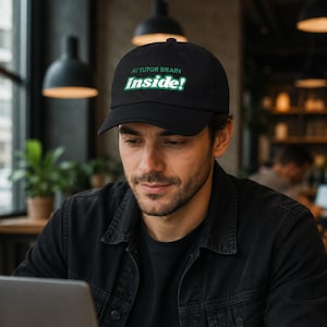 May include: A black baseball cap featuring the embroidered text AI TUTOR BRAIN in green and the word Inside! in white with a green outline. The cap has a structured crown, a curved brim, and a button on top, presenting a clean and simple design.