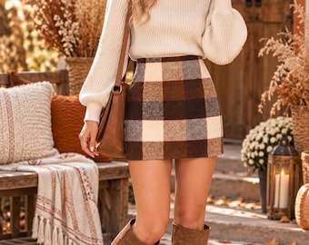 May include: A cream-colored ribbed knit sweater with long balloon sleeves and a high neckline paired with a brown, cream, and gray plaid mini skirt. A brown shoulder bag and brown knee-high boots complete the ensemble.