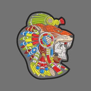 May include: An embroidered patch featuring a profile view of a skull wearing an orange jaguar headdress adorned with vibrant green, yellow, red, and blue feathers. The design includes intricate stitching details and a thick black border outline.