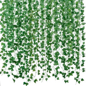 May include: A dense collection of artificial ivy vines featuring numerous small, pointed green leaves attached to thin, flexible stems. The foliage creates a layered, cascading effect with varying shades of green, mimicking natural climbing plants.