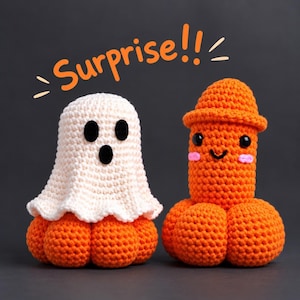 Pode incluir: Duas figuras de crochê. Uma é um fantasma branco com olhos e boca de feltro preto sobre uma base laranja. A outra é uma figura laranja de formato fálico com olhos pretos, um sorriso e bochechas rosas. O texto laranja acima diz Surprise!!