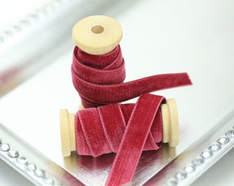 May include: Two spools of burgundy velvet ribbon, each wound around a wooden spool.
