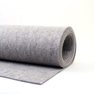 May include: A roll of gray felt fabric. The felt is rolled up and the end of the roll is visible.