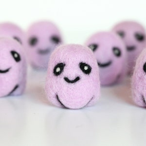 May include: A group of eight small, purple, felt balls with black embroidered eyes and smiling mouths.
