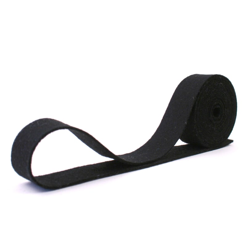 May include: A black felt ribbon rolled up on a white background.