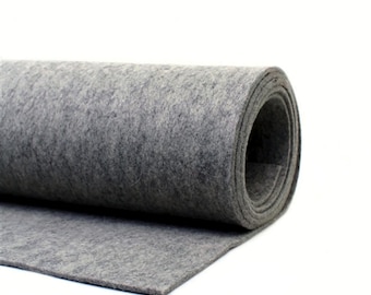 Könnte beinhalten: Eine Rolle grauen Filzstoffes. Der Filz ist aufgerollt und das Ende der Rolle ist abgewickelt, wodurch die Textur des Stoffes sichtbar wird.