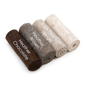 Puede incluir: Cuatro rollos de tela de fieltro en diferentes tonos de marr&oacute;n y beige. Los rollos est&aacute;n etiquetados como "Heather Chocolate", "Heather Brown", "Dark Heather Beige" y "Heather Beige".
