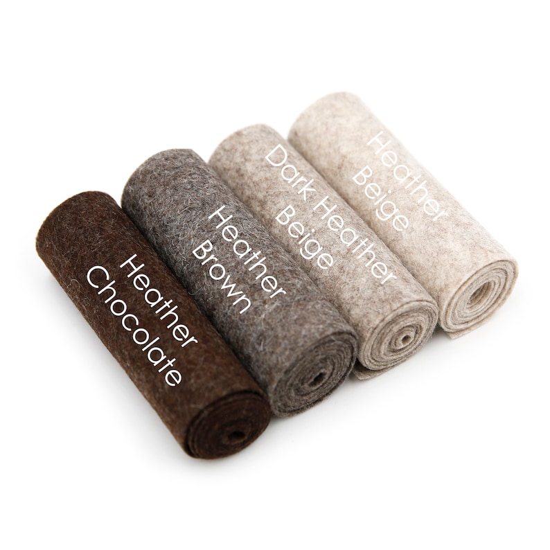 Puede incluir: Cuatro rollos de tela de fieltro en diferentes tonos de marr&oacute;n y beige. Los rollos est&aacute;n etiquetados como "Heather Chocolate", "Heather Brown", "Dark Heather Beige" y "Heather Beige".