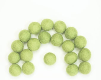 May include: A collection of 18 light green felt balls arranged in a semi-circle shape. The balls are all the same size and are made of a soft, fuzzy material.